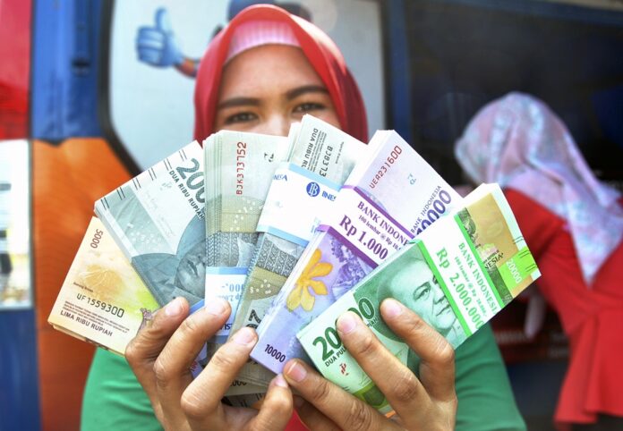 Warga menunjukkan uang pecahan kecil usai penukaran di mobil kas keliling perwakilan Bank Indonesia Provinsi Jawa Barat di Plaza Balaikota, Jawa Barat, Rabu (15/5/2019).